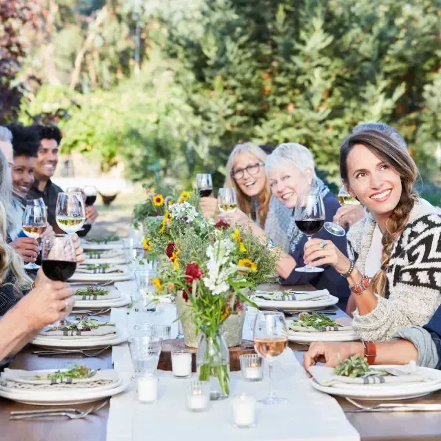 Friends at a table sharing an outdoor wine tasting